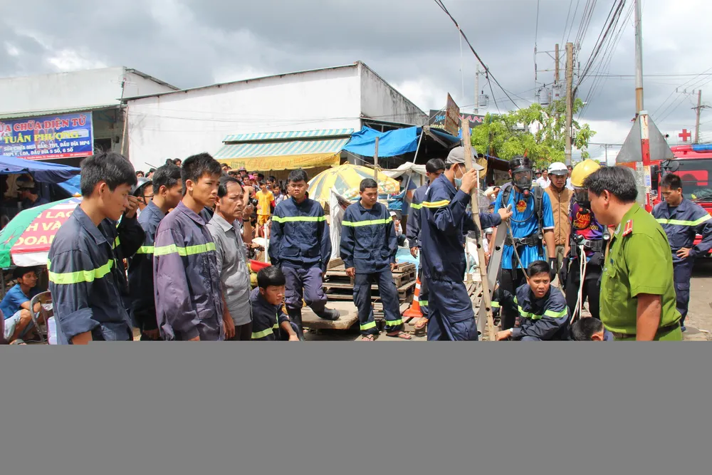 Lực lượng chức năng dỡ nắp cống để tìm kiếm - Ảnh: Bá Sơn