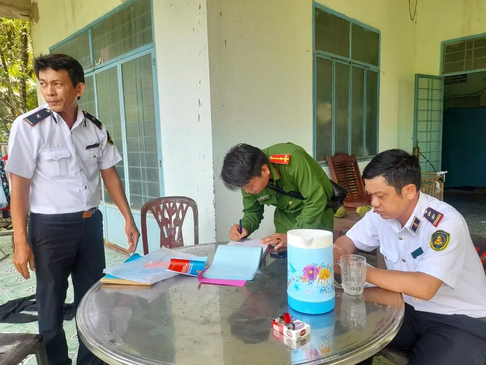 Cảng vụ cùng công an địa phương lập biên bản vi phạm đối với các sà lan neo đậu trái phép. Ảnh: Đ.HÀ