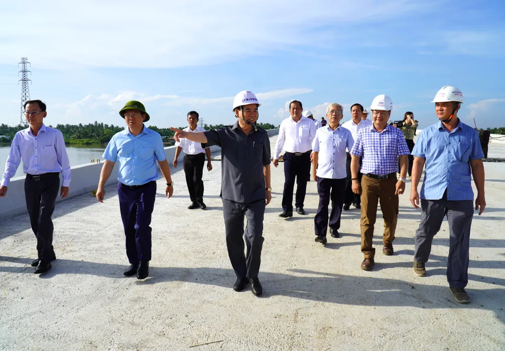 Ông Trần Ngọc Tam - Chủ tịch UBND tỉnh Bến Tre (áo xám) phấn khởi khi thấy công trình thi công vượt tiến độ Dự án cầu Rạch Miễu 2 sẽ được kéo dây văng đầu tiên vào đầu tháng 8-2024
