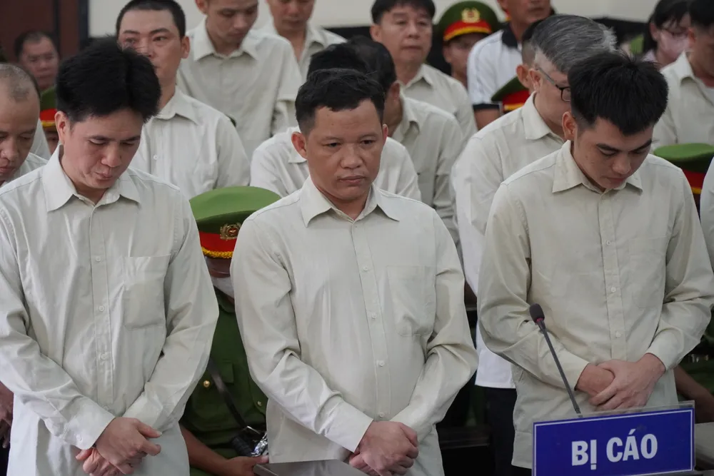 Bị cáo Lưu Tấn Tài (đứng giữa) tại phiên tòa. Lam-gia-dang-ky-xe (1).JPG