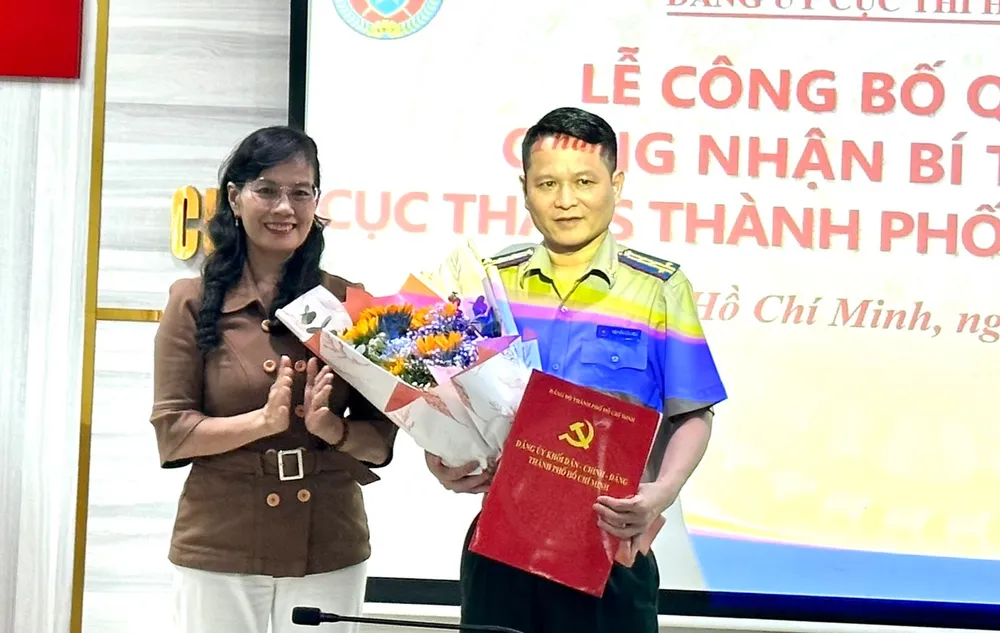 Phó Bí thư thường trực Đảng ủy Khối Dân - Chính - Đảng TP Nguyễn Thị Kim Dung trao quyết định công nhận Bí thư Đảng ủy Cục THADS TP.HCM đối với ông Nguyễn Văn Hòa. Ảnh: Cục THADS TP