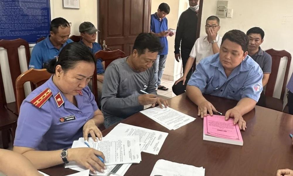 VKSND TP.HCM tống đạt cáo trạng cho các bị can trong vụ đăng kiểm. Ảnh: TC Tong dat cao trang kiem.jpg
