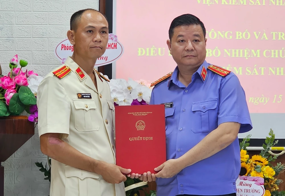 Phó viện trưởng VKSND TP.HCM Võ Quang Huy trao quyết định điều động, bổ nhiệm ông Ngô Anh Hồng (bìa trái) giữ chức vụ Phó viện trưởng VKSND quận 12. Ảnh: SONG MAI VKSND quận 12.jpg