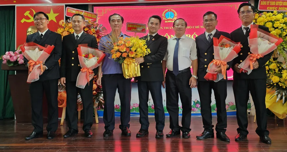 Chánh án TAND huyện Bình Chánh Vũ Thanh Lâm (áo trắng) và Viện trưởng VKSND huyện Bình Chánh Bùi Thanh Tùng (áo xanh) chụp ảnh cùng các thẩm phán được bổ nhiệm chức vụ. Ảnh: SONG MAI TAND huyện Bình Chánh.jpg