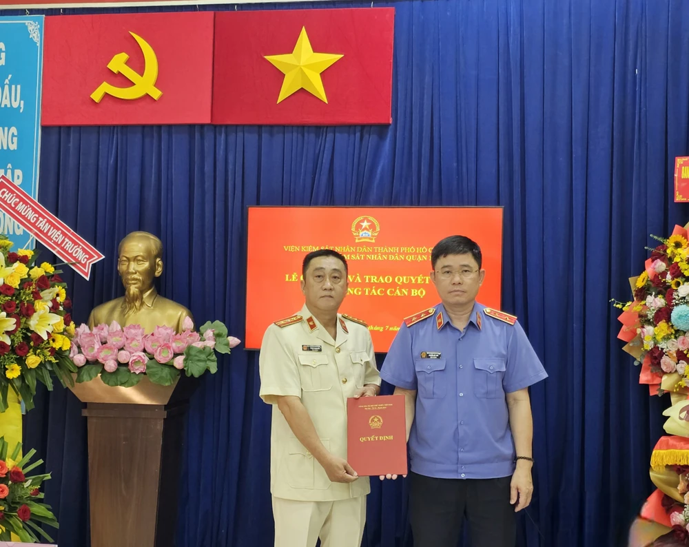 Viện trưởng VKSND TP.HCM Nguyễn Đức Thái trao quyết định cho tân Viện trưởng VKSND quận 1 Phạm Trung Kiên (bìa trái). Ảnh: SONG MAI viện trưởng VKSND quận 1.jpg