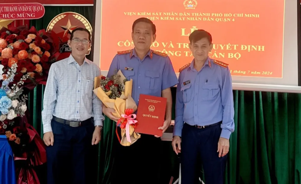 Tân Phó viện trưởng VKSND quận 4 Phạm Đức Bảo (giữa) nhận quyết định. Ảnh: TT Phó viện trưởng vks quận 4.jpg
