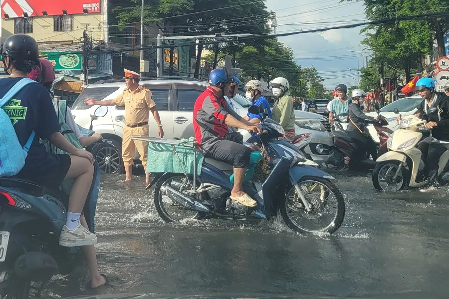 Cảnh sát giao thông xuống đường điều tiết giao thông sau cơn mưa như trút nước chỉ trong 1 tiếng đồng hồ chiều 20-8-2024. Ảnh: TRẦN VŨ Mưa như trút nước thành phố Cà Mau 1.jpg