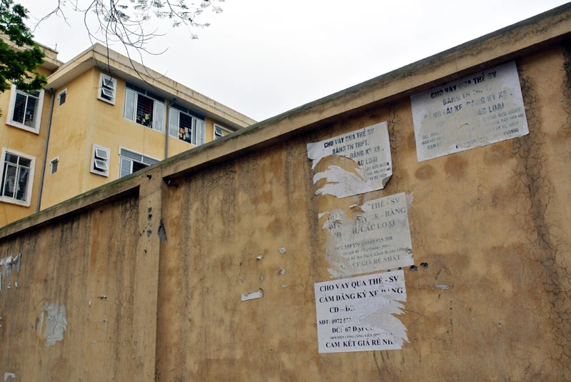 Bờ tường bao quanh ký túc xá ĐH Bách khoa nham nhở những quảng cáo rao vặt tín dụng đen.