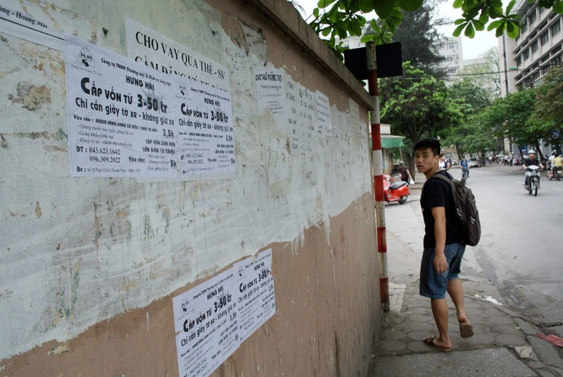 Quảng cáo tín dụng đen dán chồng chéo trên bờ tường trên phố Tạ Quang Bửu, nơi rất đông sinh viên.