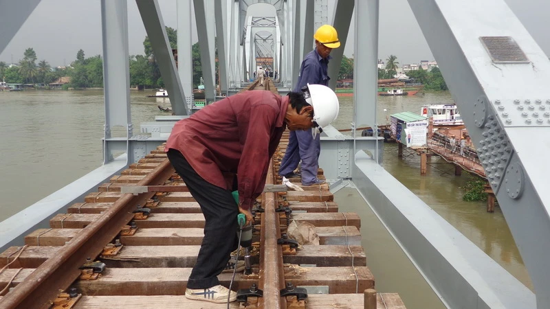 Công nhân hoàn thiện lắp ray chạy tàu trên mặt cầu Ghềnh vừa được lắp xong ba nhịp.