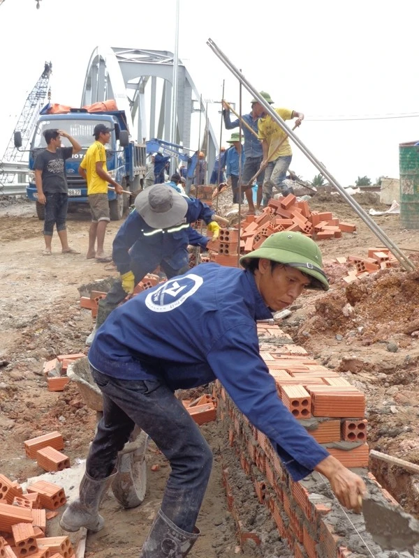 Trong sáng 29-6, công nhân gấp rút xây dựng hàng rào ngăn cách giữa đường cho xe máy với ta luy và đường ray chạy tàu.