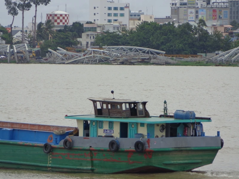 Đứng ở đầu cầu bờ Nam, phóng mắt hơn 500 mét về phía thượng bờ Bắc thấy đống sắt, thép, mái, nhịp của cầu cũ được vớt lên để tạm ở đó. 