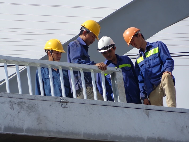 Ở điểm đầu cầu phía Bắc, công nhân lắp lan can phần cầu giành cho người đi bộ, xe máy.