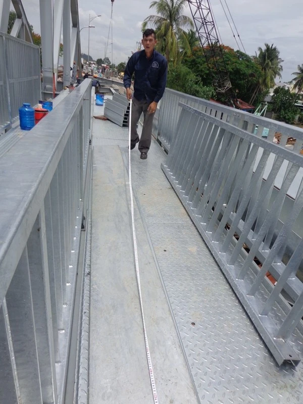 Mặt cầu đi bộ, xe máy được làm bằng những tấm thép phẳng có gân bám chống trơn trợt. Các tấm thép được bắt chặt vào đòn tay và đà dọc dưới sẽ làm cho việc đi lại êm thuận