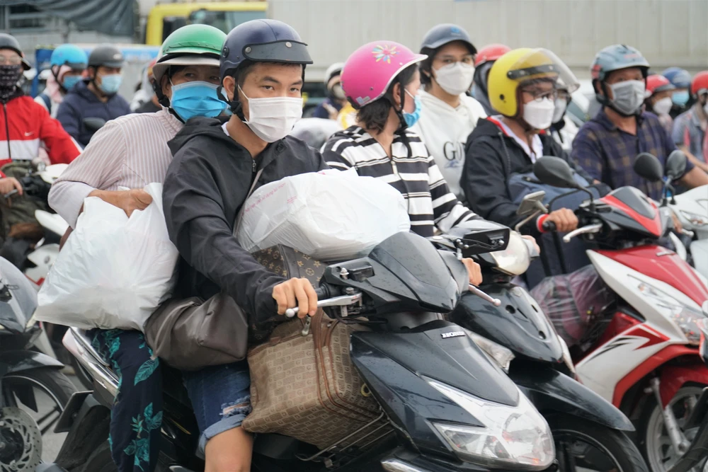 Dòng người đổ về quê mỗi lúc một đông lên, với vali, balô quần áo lỉnh kỉnh.