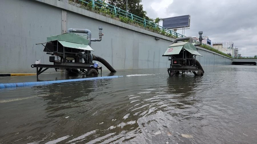 Máy bơm hút nước từ hầm chui ra ngoài. Ảnh: TẤN VIỆT