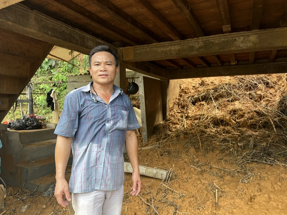 Bức tường phía sau căn nhà của anh Lưu Cảnh Thăng đã bị vỡ nát, bùn đất tràn vào kín nhà, cả móng cả nhà di chuyển 10cm về phía trước. Ảnh: TT