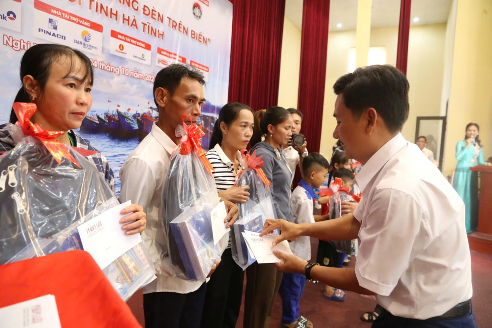 Ông Nguyễn Văn An (bên trái), Giám đốc Chi nhánh Đà Nẵng, Công ty CP Pin ắc quy miền Nam (PINACO) trao quà tặng các em học sinh là con em ngư dân Hà Tĩnh.