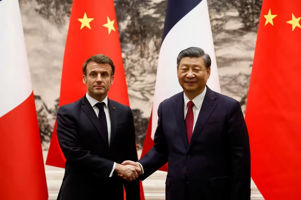 Tổng thống Pháp Emmanuel Macron (trái) bắt tay Chủ tịch Trung Quốc Tập Cận Bình tại Bắc Kinh hôm 6-4. Ảnh: REUTERS