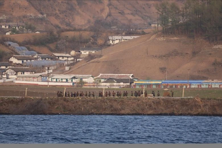 Nông dân Triều Tiên trên một cánh đồng chụp từ Đan Đông, tỉnh Liêu Ninh, Trung Quốc. Ảnh: Tingshu Wang/REUTERS