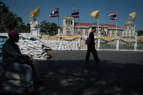 [Caption]Thai anti-government protesters walk and sit outside the Government house in Bangkok on January 12, 2014.