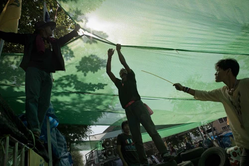 [Caption]Thai anti-government protesters set up a spot with shade on a street outside the Government house in Bangkok on January 12, 2014.