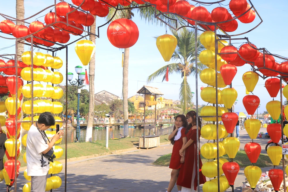 Các bạn trẻ thích thú chụp ảnh với những chiếc đèn lồng rực rỡ của phố cổ Hội An.
