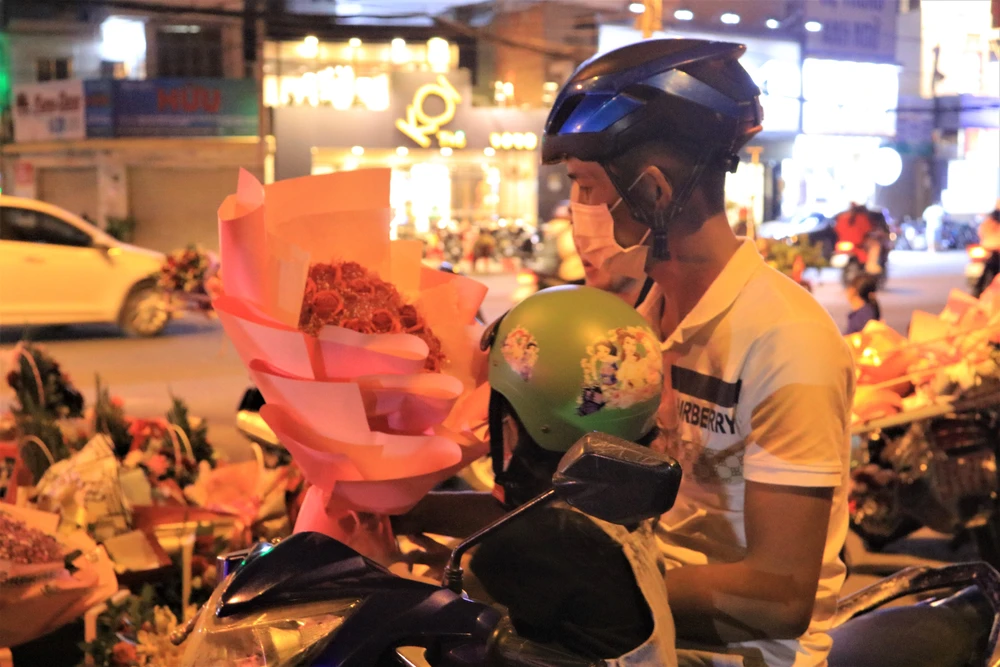 Nhiều người thường chọn mua tại các sạp hoa của sinh viên một phần vì hoa tự gói khá đẹp một phần để ủng hộ các bạn. Ảnh VÕ THƠ