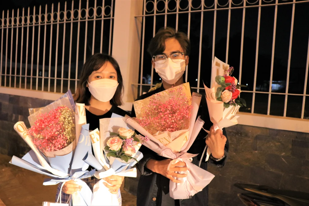 Thành Phúc (phải) và bạn thân tranh thủ bán hoa để mua các thiết bị phục vụ việc học. Ảnh: VÕ THƠ