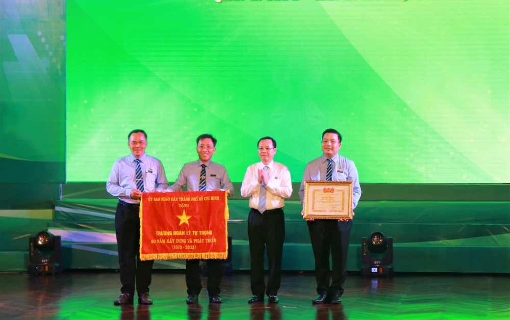 Phó Bí thư Thành ủy TP.HCM Nguyễn Văn Hiếu tặng Cờ truyền thống của UBND TP.HCM cho lãnh đạo Trường Đoàn Lý Tự Trọng Ảnh: VT