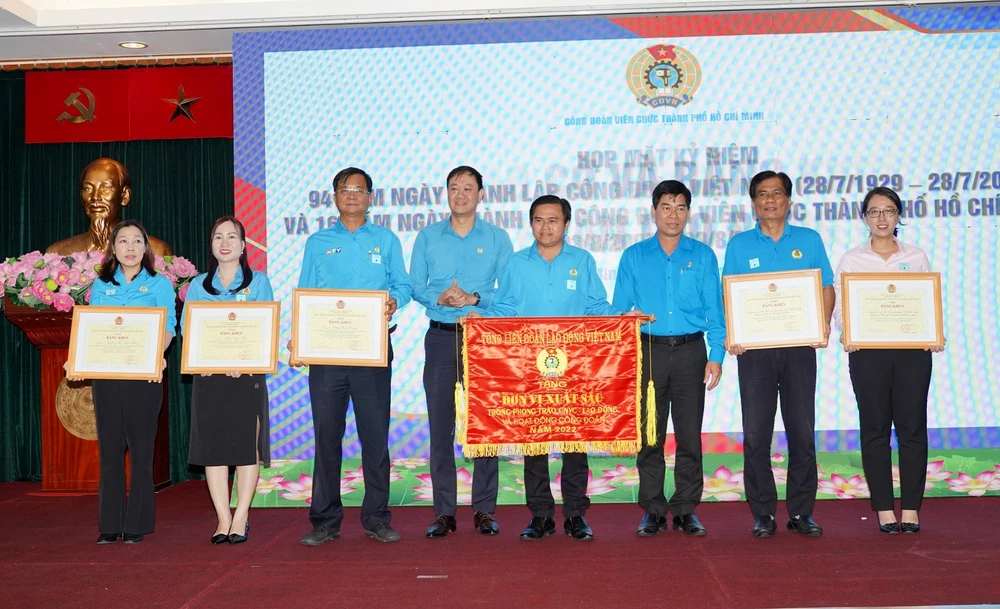 Phó Chủ tịch LĐLĐ TP.HCM Phạm Chí Tâm và Chủ tịch CĐVC TP.HCM Lương Tuấn Anh trao Cờ và Bằng khen cho các tập thể và cá nhân. Ảnh: VÕ THƠ