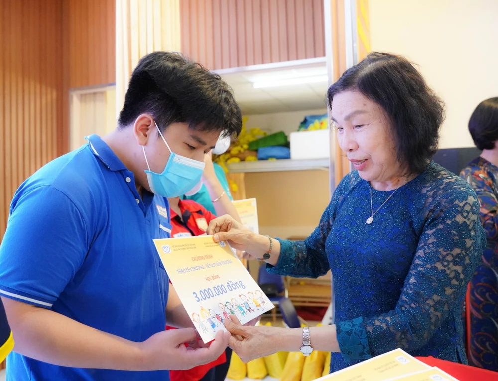 Chủ tịch Hội Bảo vệ quyền trẻ em TP.HCM Mai Thị Ngọc Mai trao học bổng cho một học sinh mồ côi do COVID-19 có thành tích xuất sắc vượt khó trong học tập. Ảnh: VT