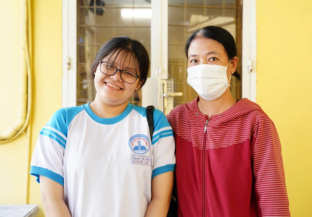 Chị Nguyễn Thị Hạnh cùng con gái Bảo Hân đến nhận học bổng. Ảnh: VT
