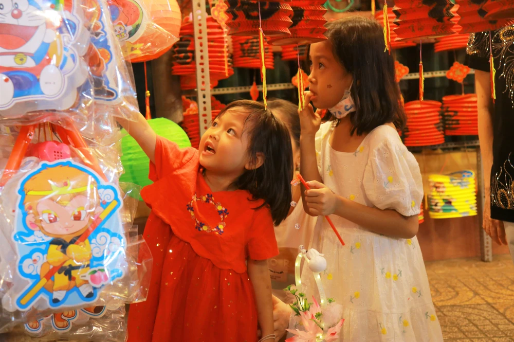 Nhiều em nhỏ được bố mẹ dắt đến đây vui chơi. Những món đồ chơi truyền thống như mặt nạ, đầu lân, đèn lồng nhiều màu sắc thu hút các em nhỏ.