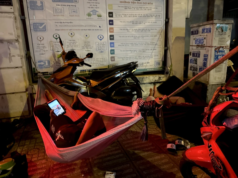 Một số người dân mắc võng nằm tạm chờ cả đêm để rút Bảo hiểm xã hội. Ảnh: TRẦN MINH