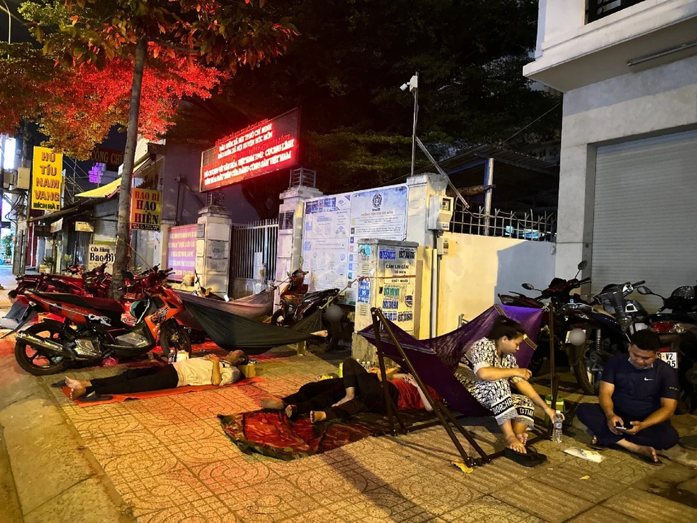 Hai vợ chồng chị Thạch Hồng Anh và anh Nguyễn Chí Hiếu đến trước cổng cơ quan Bảo hiểm xã hội huyện Hóc Môn lúc 19 giờ. Ảnh: TRẦN MINH