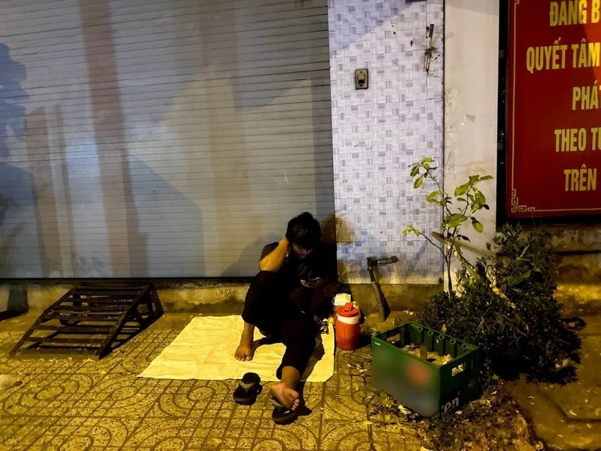 Anh Trần Minh Bảo phờ phạc sau nhiều giờ liền ngồi chờ đợi ngoài cổng trụ sở BHXH (huyện Hóc Môn, TPHCM). Ảnh: TRẦN MINH