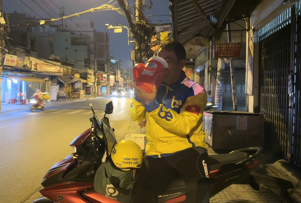 Anh Đức chạy xe ôm công nghệ cho biết: Mấy nay trời đêm nóng quá nên ra đường tôi đều đem theo ca nước đá bự hơn mọi hôm, bình thường thì đem theo chai nước nhưng nay phải đem theo bình giữ nhiệt để đựng đá uống cho mát. Ảnh: THẢO HIỀN