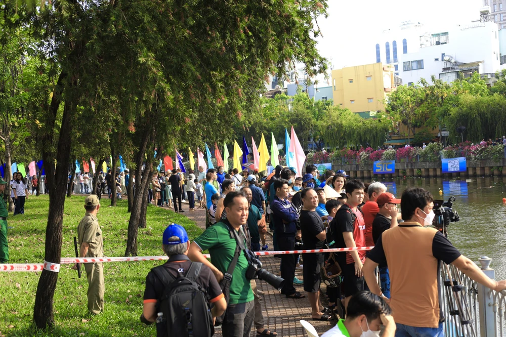 Dù 7 giờ mới bắt đầu nhưng theo ghi nhận của PLO, ngay từ sáng sớm, rất đông người dân đã đổ về hai bên bờ kênh Nhiêu Lộc (quận 3), nhất là đoạn cầu Công Lý đến cầu Lê Văn Sỹ để theo dõi quá trình chuẩn bị, cũng như đứng hò reo, cổ vũ nhiệt tình cho các đội đua ghe khi cuộc đua bắt đầu. Ảnh: TRẦN MINH