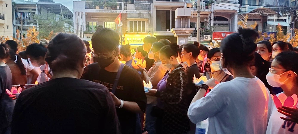 Người dân và tăng ni, phật tử cùng nhau cầu nguyện sự bình an. Ảnh: MINH ĐỦ