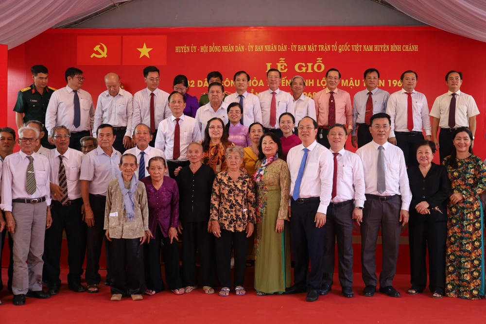 Các đồng chí lãnh đạo chụp hình lưu niệm cùng với thân nhân 32 Liệt sĩ dân công hỏa tuyến và cựu Dân công Vĩnh Lộc. Ảnh: TRẦN MINH