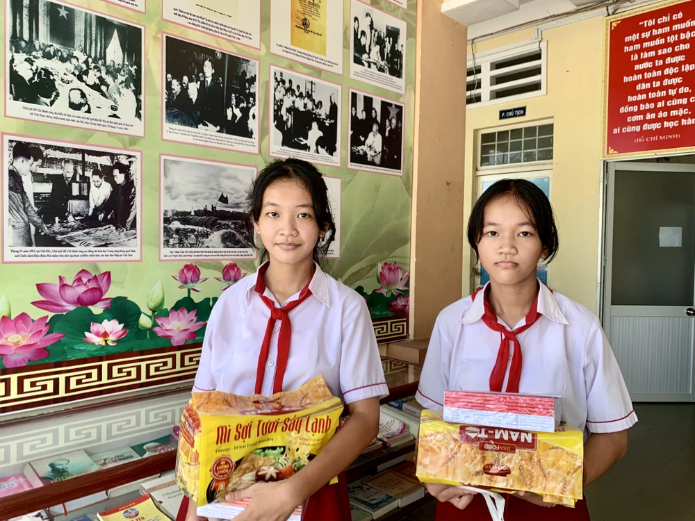 Hai chị em Bảo Thy và Anh Thy được nhận học bổng và những phần quà cho năm học mới 2023 - 2024. Ảnh: TRẦN MINH