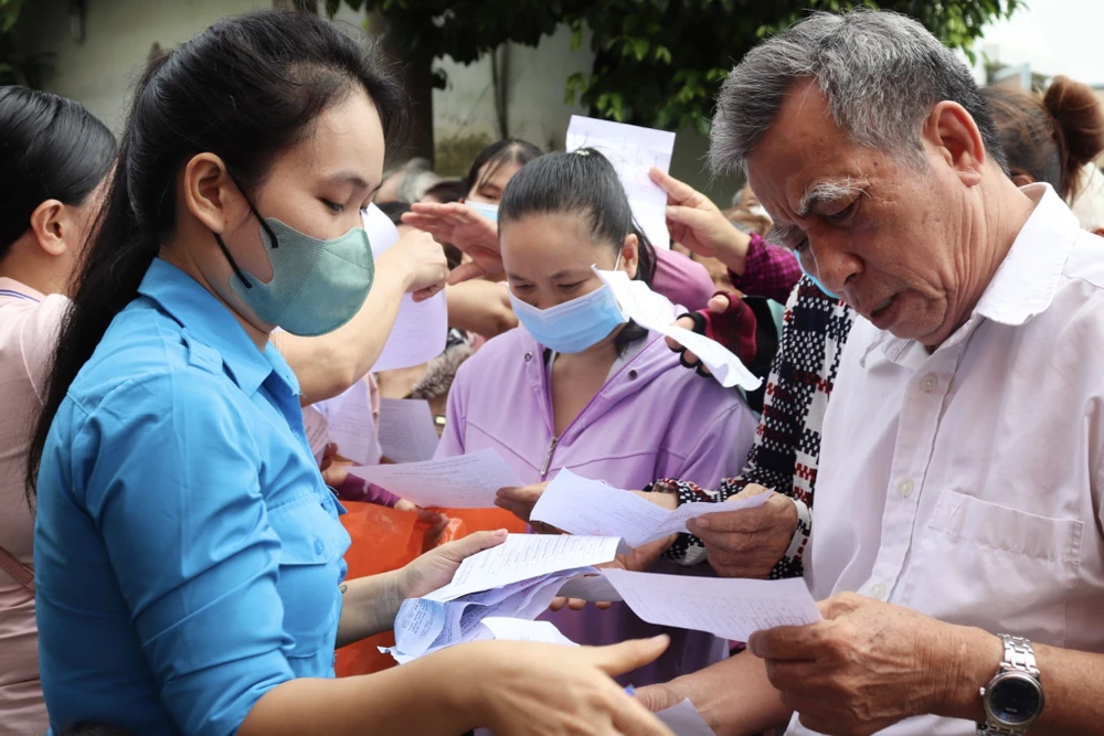 Mỗi người dân được phát số thứ tự để lần lượt đi chợ "0 đồng". Ảnh: BẢO PHƯƠNG Mỗi người dân được phát số thứ tự để lần lượt đi chợ "0 đồng". Ảnh: BẢO PHƯƠNG