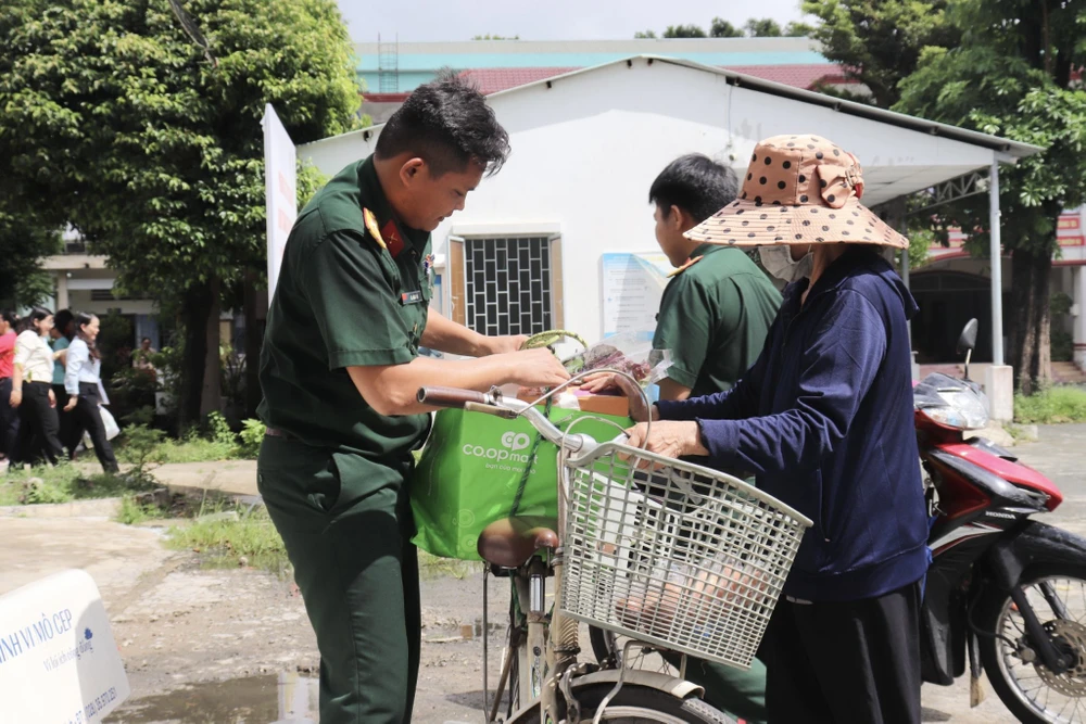 Người dân vui mừng ra về với những phần quà. Ảnh: TRẦN MINH Người dân vui mừng ra về với những phần quà. Ảnh: TRẦN MINH