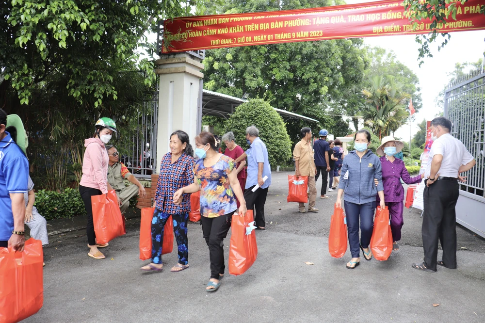 Người dân vui mừng nhận được những phần quà hỗ trợ. Ảnh: TRẦN MINH