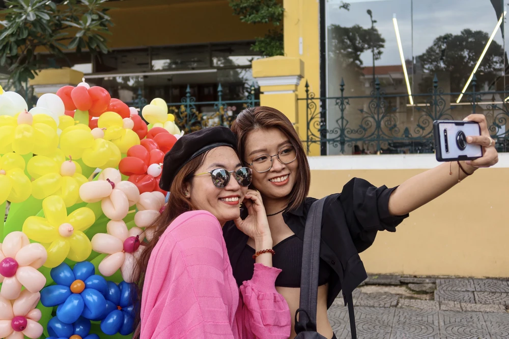 Người dân còn thích thú chụp hình bên những chiếc xe bong bóng. Ảnh: HUỲNH THƠ