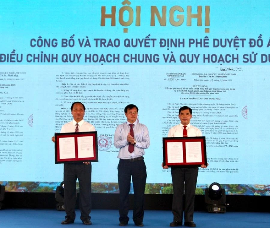 Chủ tịch UBND tỉnh Cao Tiến Dũng (giữa) trao quyết định phê duyệt đồ án diều chỉnh TP Long Khánh cho lãnh đạo UBND TP Long Khánh. Ảnh: VH.