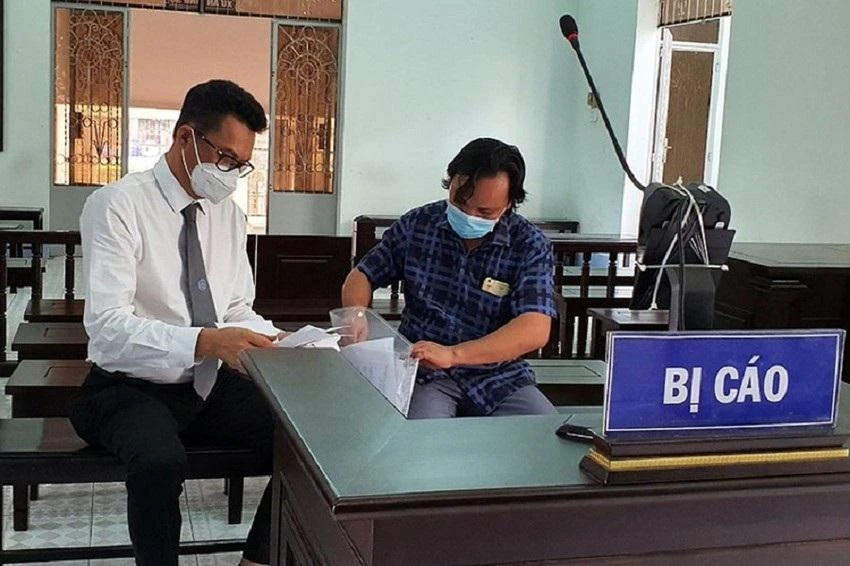 Ông Khanh (bên phải) trao đổi với luật sư tại tòa. Ảnh: VH.