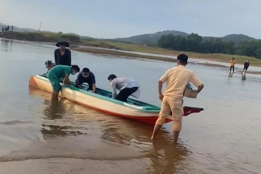 Lực lượng chức năng tìm kiếm đưa thi thể một người đàn ông vào bờ. Ảnh: VH