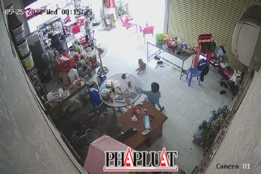 Hình ảnh camera ghi lại bé gái cầm chiếc điện thoại trên bàn cho vào túi rồi đi ra ngoài.